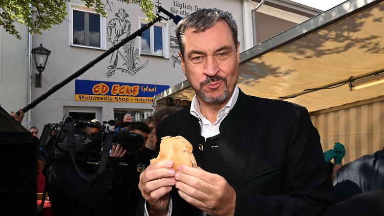 Söder amüsiert sich beim Schweinewettgrillen